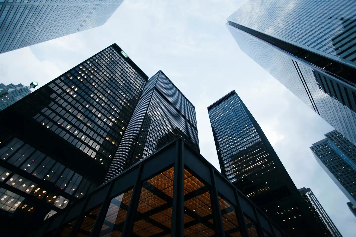 Looking up at glass skyscrapers in a downtown business district at dusk